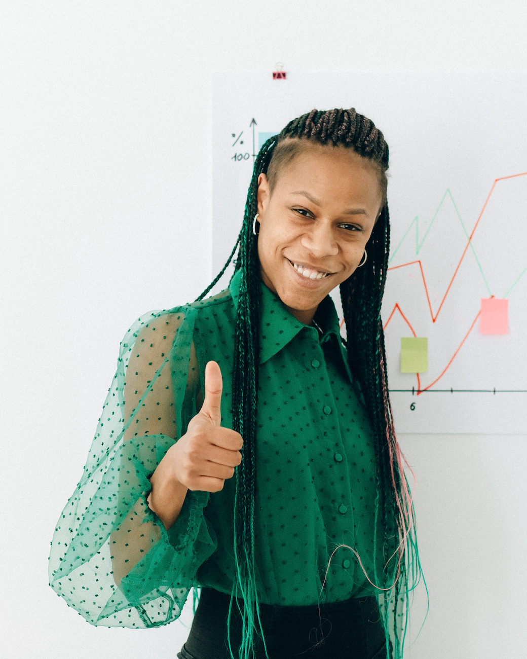 a teacher in a green shirt giving a happy thumbs up