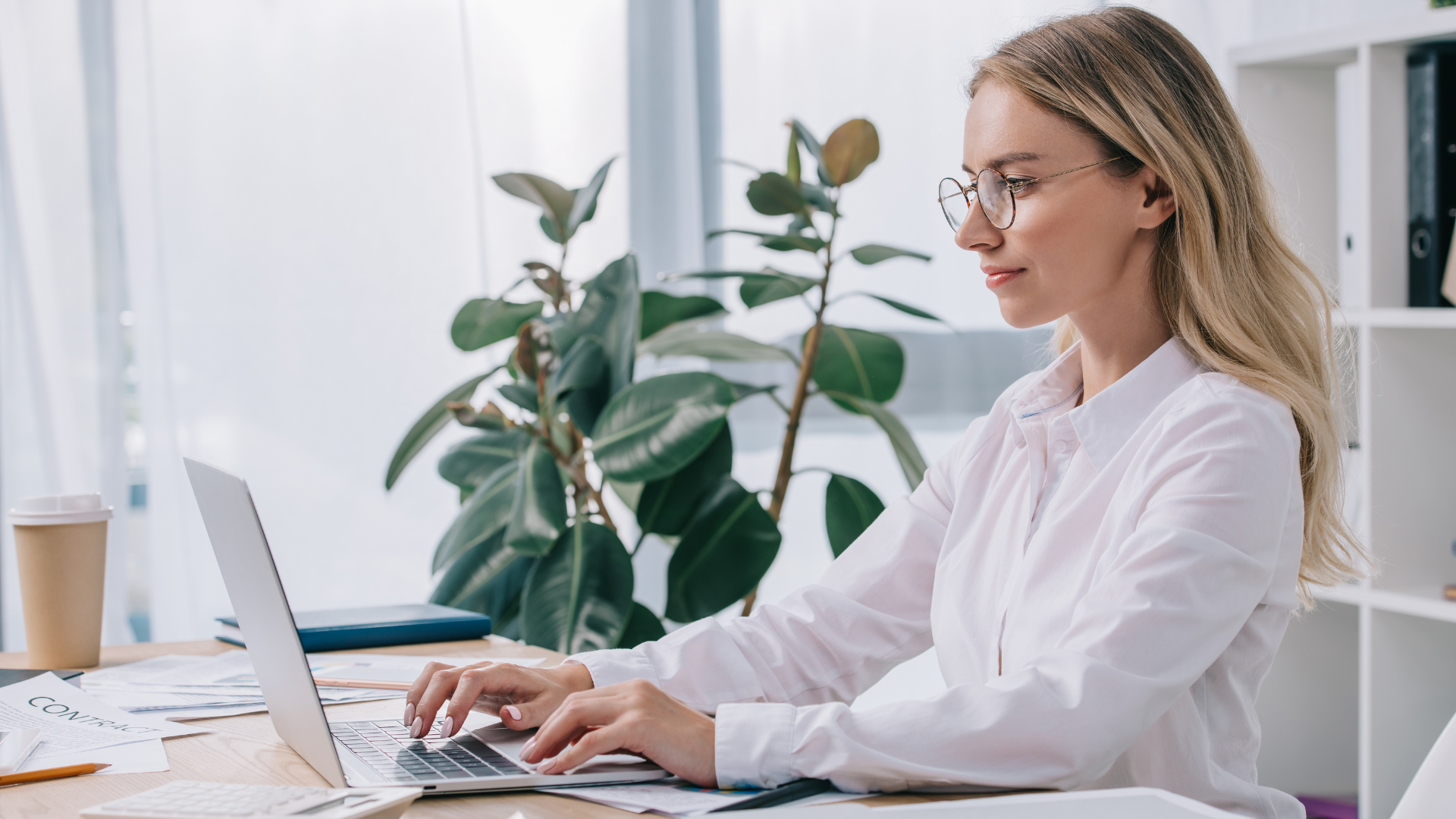 woman typing on computer with plants in background