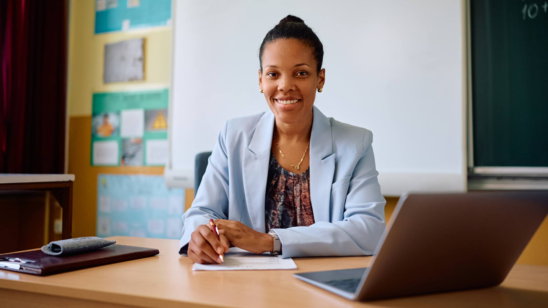 happy charter school principal sitting at desk