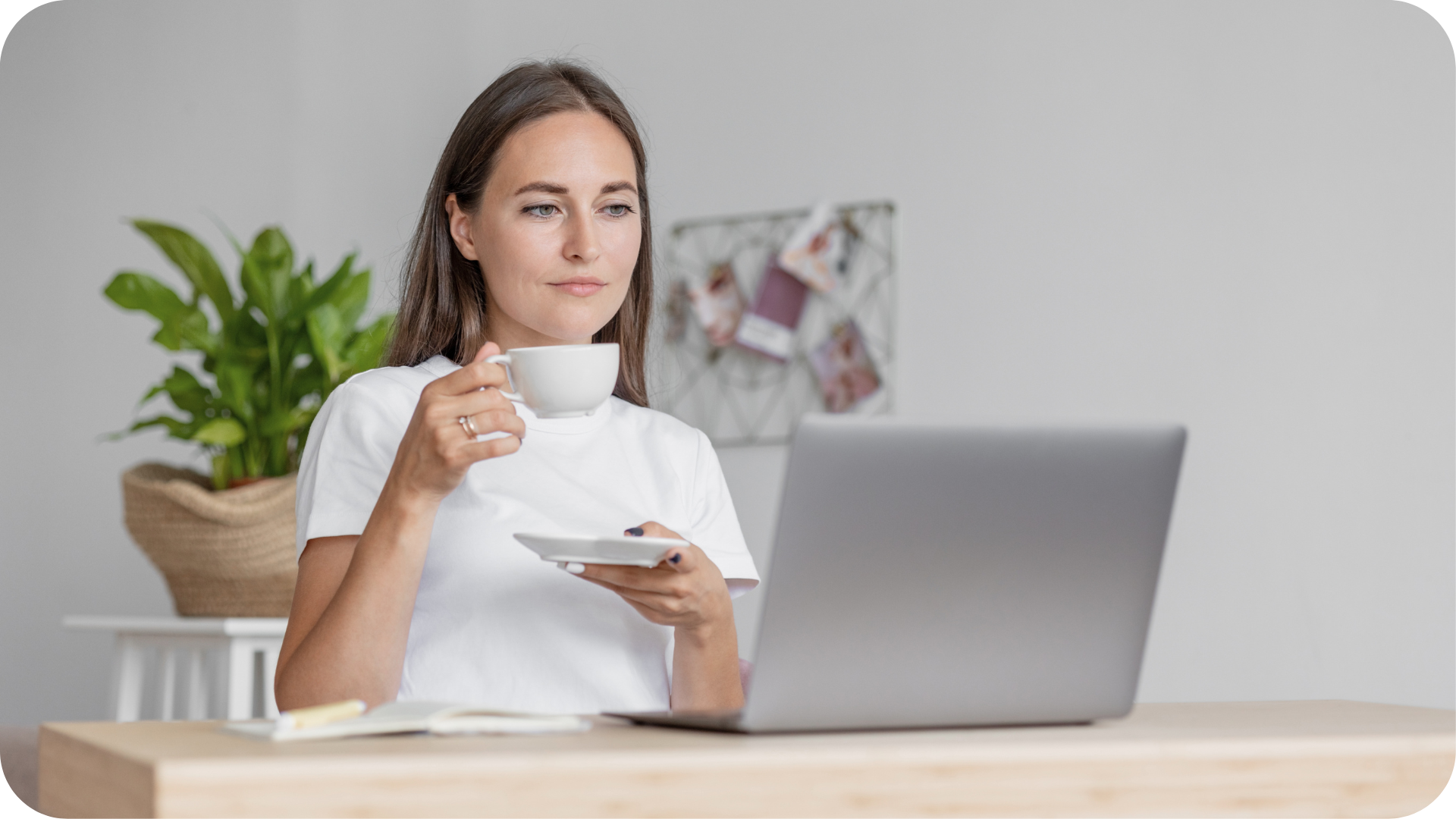 woman sitting at computer and sipping drink
