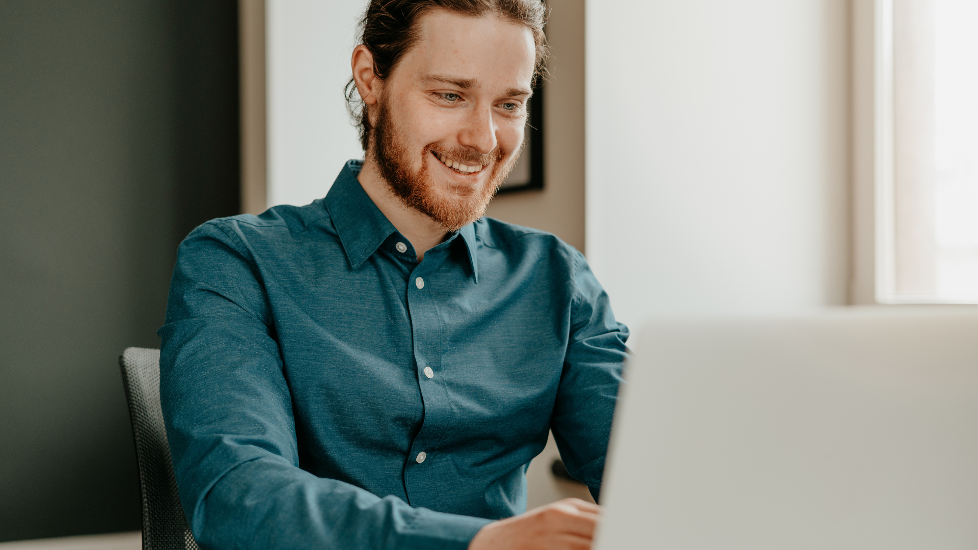smiling young man working on computer